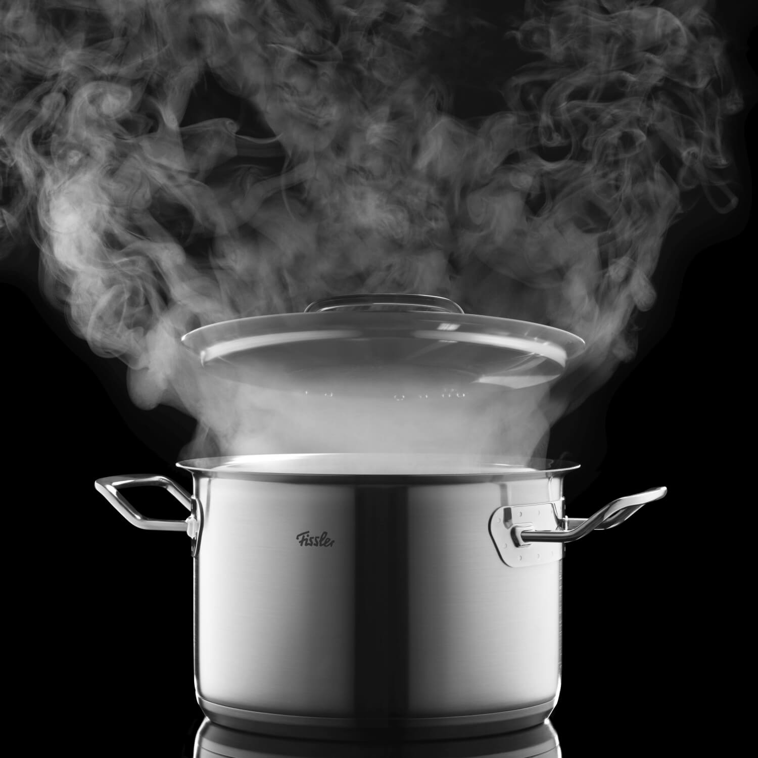 Ein dampfender Kochtopf von Fissler vor schwarzem Hintergrund – modernes, edles Design für energieeffizientes Kochen