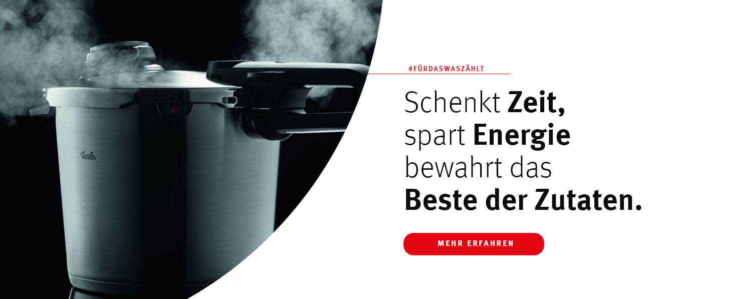 Ein dampfender Fissler Schnellkochtopf vor schwarzem Hintergrund – modernes Design trifft auf effizientes Kochen mit Stil